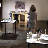 Gallery visitor admiring ceramic display at The Vault art gallery