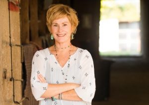 Photo of Kim Robbins standing in a barn